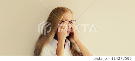 Tired overworked woman employee rubbing her eyes suffering from eye strain, dry eye syndrome Tired overworked woman employee rubbing her eyes suffering from eye strain, dry eye syndrome 114273599