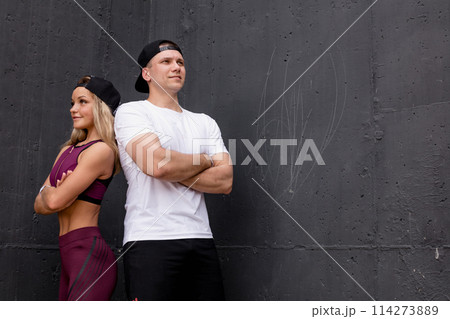 Smiling sportive caucasian couple posing over grey background 114273889