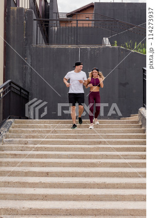 Couple running on stairs in morning, jogging in urban area with starecases. Couple running on stairs in morning, jogging in urban area with starecases. 114273937