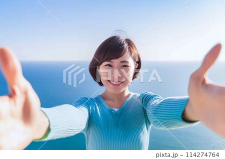 両手を広げてウェルカムポーズをする女性 両手を広げてウェルカムポーズをする女性 114274764