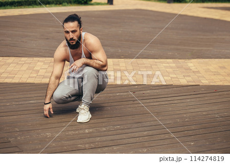 Athletic man with muscular body resting after workout outdoors 114274819
