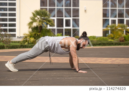 Muscular bearded man in sporty wear working out doing extreme pushups 114274820