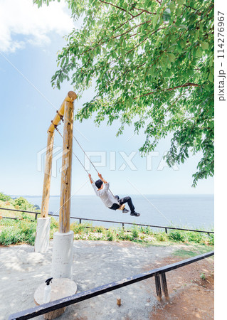 《静岡県》　熱海のACAO FOREST　SNS映えスポット　空飛ぶブランコを楽しむ男性 114276967