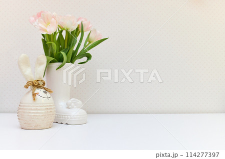 bouquet of tulips and Easter bunny on white table. copy space bouquet of tulips and Easter bunny on white table. copy space 114277397