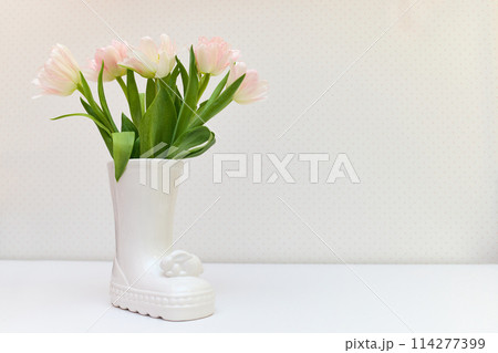 bouquet of tulips in Easter bunny vase on white table. copy space bouquet of tulips in Easter bunny vase on white table. copy space 114277399