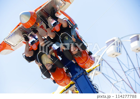 Teenagers ride head down on a carousel. Extreme rides in the park. Teenagers ride head down on a carousel. Extreme rides in the park. 114277788