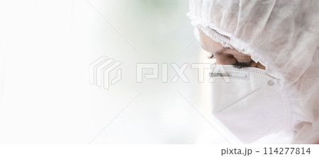 The face of a doctor in a protective medical mask and suit close-up on a white background. 114277814