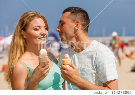 Man and woman eating ice cream on beach 114278899