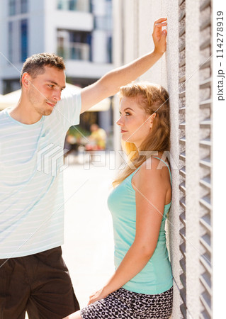 Man flirting with girl on city street Man flirting with girl on city street 114278919