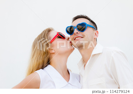 Man and woman wearing heart shape sunglasses Man and woman wearing heart shape sunglasses 114279124
