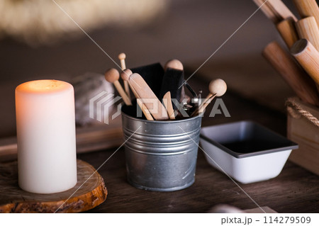 Ceramics. Objects for working with clay, stacks, sticks, brushes standing in a bucket 114279509