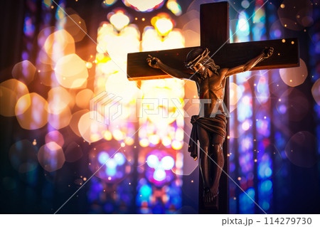 Crucifix with Jesus Christ on cross in church with light coming through stained glass windows - symbol of christian faith religion 114279730