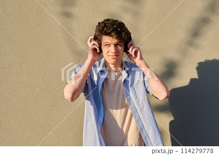 Young handsome male in wireless headphones listening to music 114279778