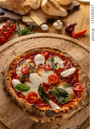 Pizza topped with fresh tomatoes and mozzarella 114280027