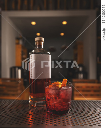Artisanal cocktail on bar counter with whiskey bottle Artisanal cocktail on bar counter with whiskey bottle 114280051