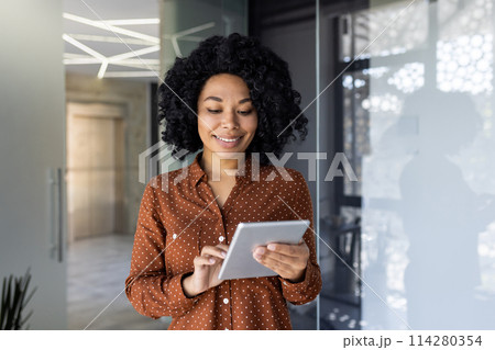 Young and successful female programmer, portrait of female engineer with tablet computer startup worker working inside office building using tablet for testing applications smiling . 114280354