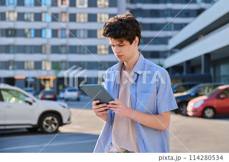 Young handsome male using digital tablet on city street Young handsome male using digital tablet on city street 114280534