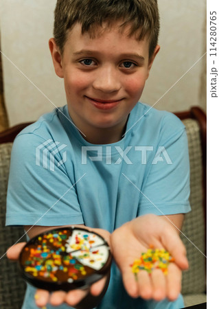 Boy proudly holds a bowl of colorful sprinkles 114280765