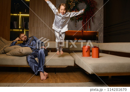 A happy family poses in pajamas in New Year's locations. 114281670