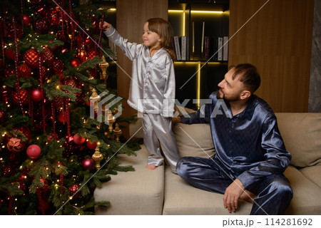 A happy family poses in pajamas in New Year's locations. 114281692