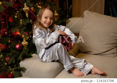 A happy family poses in pajamas in New Year's locations. A happy family poses in pajamas in New Year's locations. 114281706