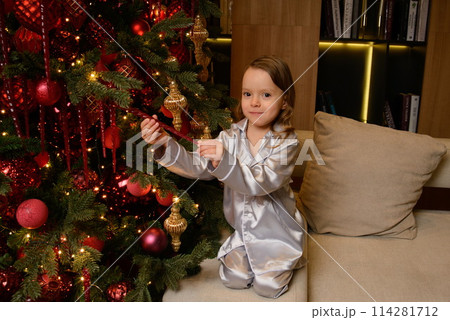 A happy family poses in pajamas in New Year's locations. 114281712