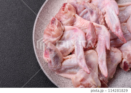 Fresh chicken wings with salt, spices and herbs Fresh chicken wings with salt, spices and herbs 114281829