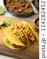 yellow hard shell tacos  on cutting board 114282452