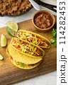 yellow hard shell tacos  on cutting board 114282453