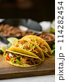 yellow hard shell tacos  on cutting board 114282454