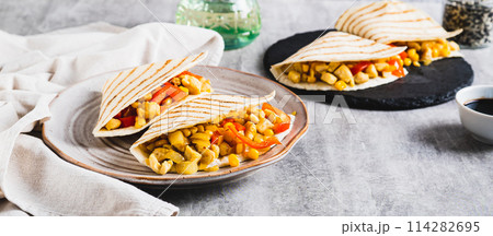 Mexican quesadilla with chicken, corn and bell pepper on a plate on the table web banner 114282695