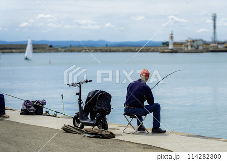 Fisherman with fish rod on sea dock, fishing, vacations sport, hobby Fisherman with fish rod on sea dock, fishing, vacations sport, hobby 114282800