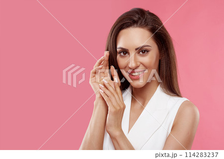 Beautiful young woman with clean perfect skin. Portrait of beauty model with natural nude make up and touching her face. Spa, skincare and wellness. Close up, copyspace. 114283237