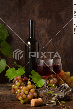 Still life with glasses of red wine and grapes on vintage wooden background.. 114284351