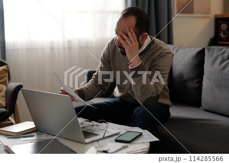 Young troubled man with financial bill Young troubled man with financial bill 114285566