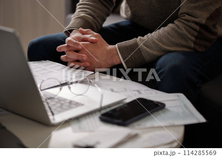 Clasped hands of man checking data 114285569