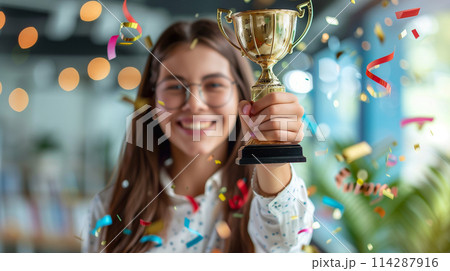 A woman is holding a trophy and smiling 114287916