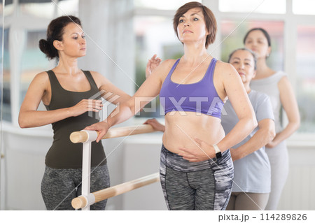 Adult woman teacher correcting beginning dancers 114289826