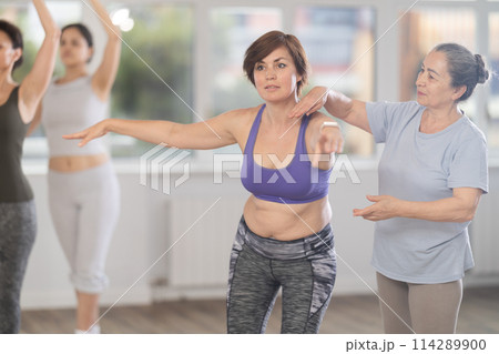 Choreographer coach teaches amateur students to keep their heads straight during ballet lesson 114289900