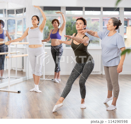 Elderly woman teacher correcting female dancers Elderly woman teacher correcting female dancers 114290598