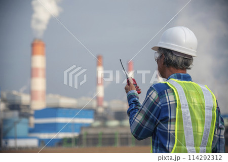 Senior Electrician engineer man hand holding red Walkie talkie communicate wear White hardhat at Power stations manufacturing electrical plant. Technician worker blue hard hat helmet Engineer industry 114292312