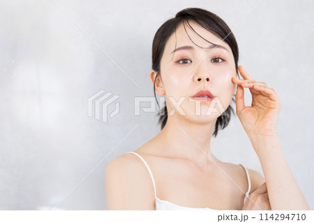 白いドレスを着た美しいアンニュイな表情の女性　美容・ビューティー　美白や艶、スキンケア カメラ目線 114294710