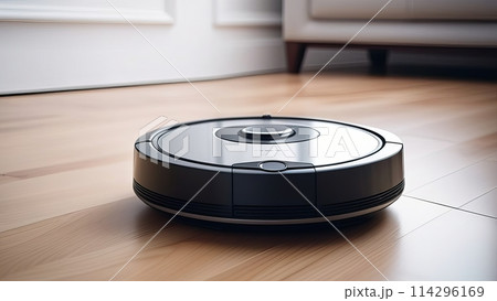 A modern robot vacuum cleaner moving across a wooden laminate in a room 114296169