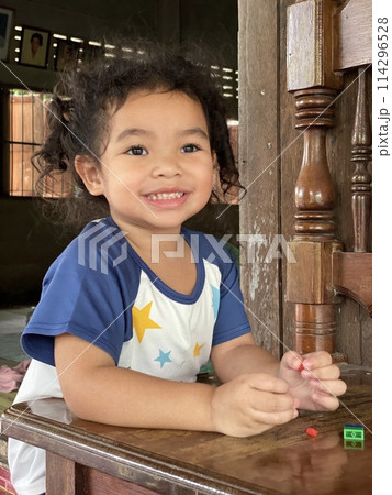 Happy little girl playing with wooden stairs in the house. Kids play at home. Happy little girl playing with wooden stairs in the house. Kids play at home. 114296528