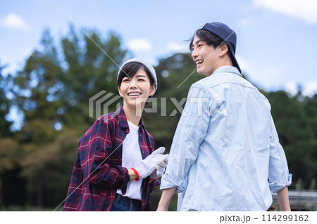 畑で野菜を収穫する男女 114299162