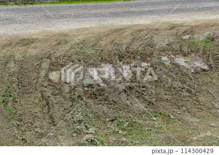 泥道に付いたタイヤの痕　Dirty country road with deep rut 114300429