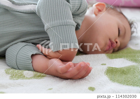 close-up portrait of a beautiful sleeping baby on bed. New family and baby protection from mom concept 114302030
