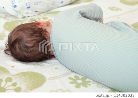 close-up portrait of a beautiful sleeping baby on bed. New family and baby protection from mom concept close-up portrait of a beautiful sleeping baby on bed. New family and baby protection from mom concept 114302035