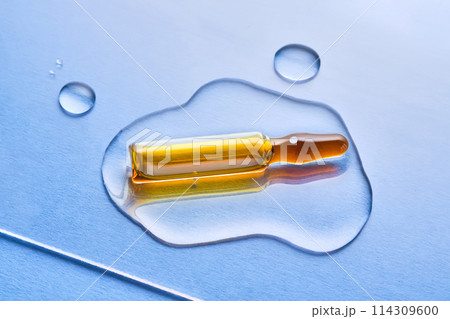 Ampoules in liquid on a blue background. Ampoules in liquid on a blue background. 114309600
