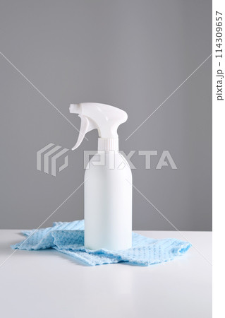 Cleaning product with a sprayer on a background of a blue microfiber cloth. Cleaning product with a sprayer on a background of a blue microfiber cloth. 114309657